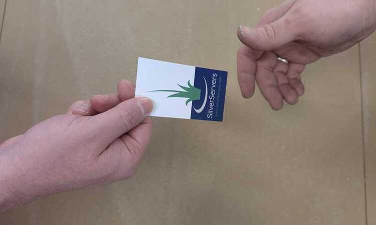 One hand passing a SilverServers business card to another